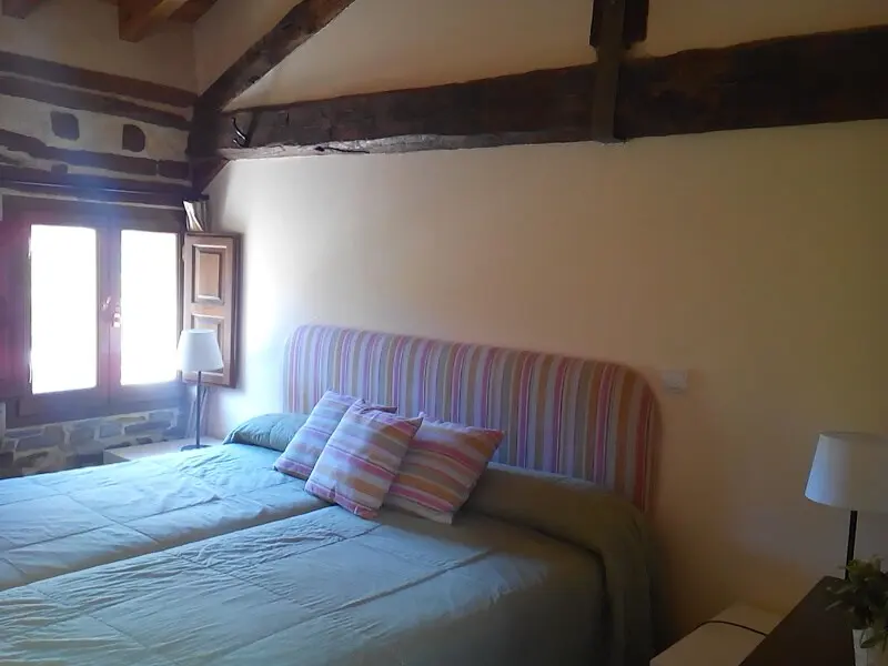 Dormitorio doble bajo techo abuhardillado de madera