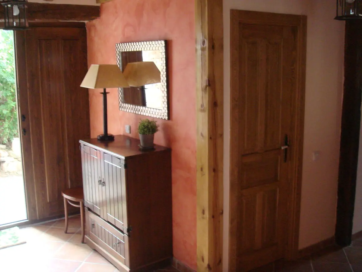 Recibidor de la casa con paredes color terracota y mueble de madera